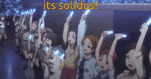 a group of people are holding up their glowing sticks with the words " its solidus " behind them