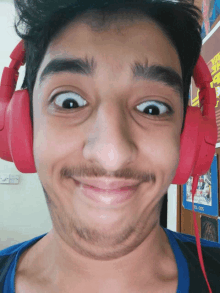 a man wearing red headphones is making a face