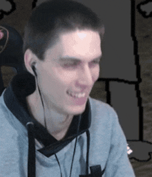 a man wearing ear buds is smiling and looking down