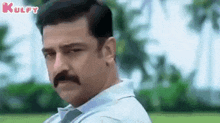 a man with a mustache is making a funny face .