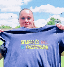 a woman is holding up a shirt that says sempre es exceptional