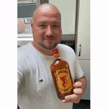 a man holding a bottle of fire devils rum