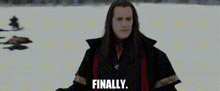 a man with long hair is standing in the snow with the words `` finally '' written on the screen .