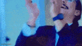 a man in a suit is singing into a microphone .