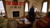 a man standing in a living room with the words i 'm that bitch written in red
