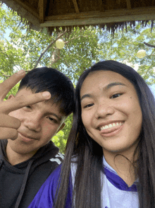a boy and a girl are posing for a picture and the girl is wearing a shirt that says ' basketball '
