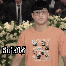 a man wearing glasses and an orange shirt that says vogue on it