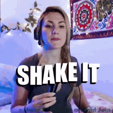 a woman wearing headphones is holding a microphone and the words shake it are above her