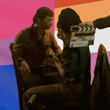 a man is holding a clapper board that says ' hollywood ' on the front