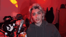 a person is standing in front of a microphone holding a can of soda .