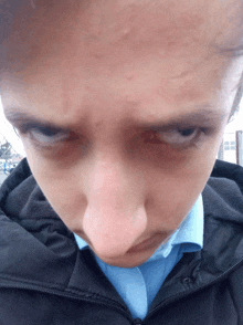 a close up of a person 's face with a black jacket