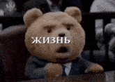 a teddy bear wearing a suit and tie is sitting in front of a microphone with a spider web on its face