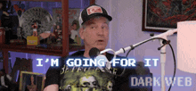a man in a hat is talking into a microphone and says i 'm going for it dark web