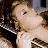 a close up of a woman laying down with her eyes closed