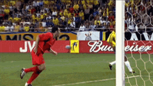 a soccer game is being played in front of ads for budweiser