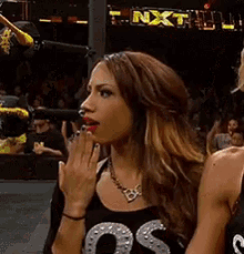a woman is standing in front of a sign that says nxt on it