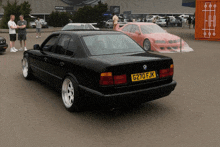 a black bmw with a yellow license plate that says g270 fjk
