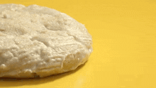 a close up of a cookie with white frosting on it on a yellow surface