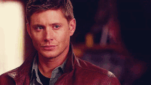 a close up of a man wearing a leather jacket