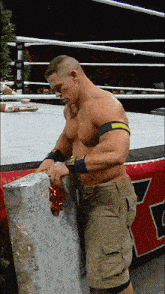 a man in a wrestling ring is wrapping a gift with a bow
