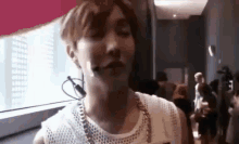 a close up of a man wearing a microphone and a necklace .