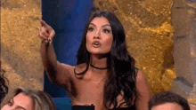a woman is pointing at something while sitting in a chair .