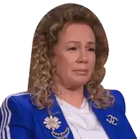 a woman with curly hair wearing a blue jacket with chanel brooch