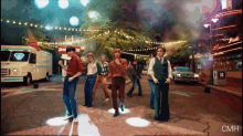 a group of men are dancing in front of a building that says music