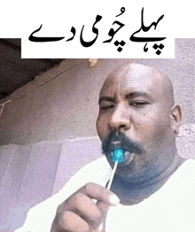 a man with a mustache is eating a lollipop in a foreign language