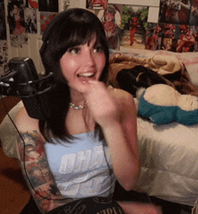 a woman wearing headphones and a tank top that says oha