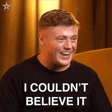 a man wearing a black shirt that says " i couldn 't believe it "