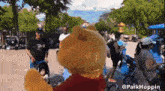 a winnie the pooh mascot is standing in front of a crowd