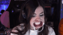 a woman wearing headphones and a mouth guard with the word dxr on the back of her chair