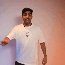 a man wearing a white nike t-shirt giving an ok sign