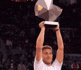 a man is holding a trophy in the air