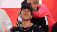 a man wearing a black shirt that says telcel on it is laughing