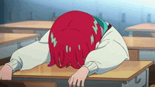a girl with red hair is laying on a desk