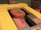 a red cushion sits on a yellow couch next to a sign that says " warning "