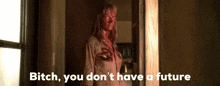 a woman with blood on her face is standing in a doorway and says bitch you don 't have a future