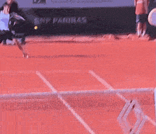 a tennis ball is being thrown in the air on a red court