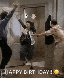 a group of people are jumping in the air in front of a door with the words `` happy birthday '' written on the bottom .