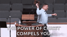 a man is standing at a podium in front of a microphone holding a bible in his hand .