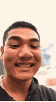 a young man is smiling and looking at the camera