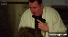 a man in a white coat is holding a gun in his hand