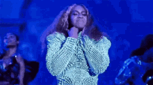 a woman is dancing on a stage in front of a blue background .