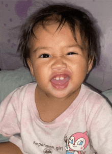 a baby wearing an anpanman girl shirt making a face