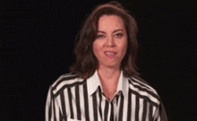 a woman is wearing a striped shirt and smiling .