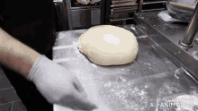 a person is kneading a ball of dough on a counter with the words made in animatica below it