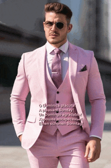 a man wearing a pink suit and tie is standing on a street