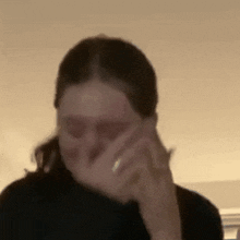 a woman with a ring on her finger is covering her mouth with her hand